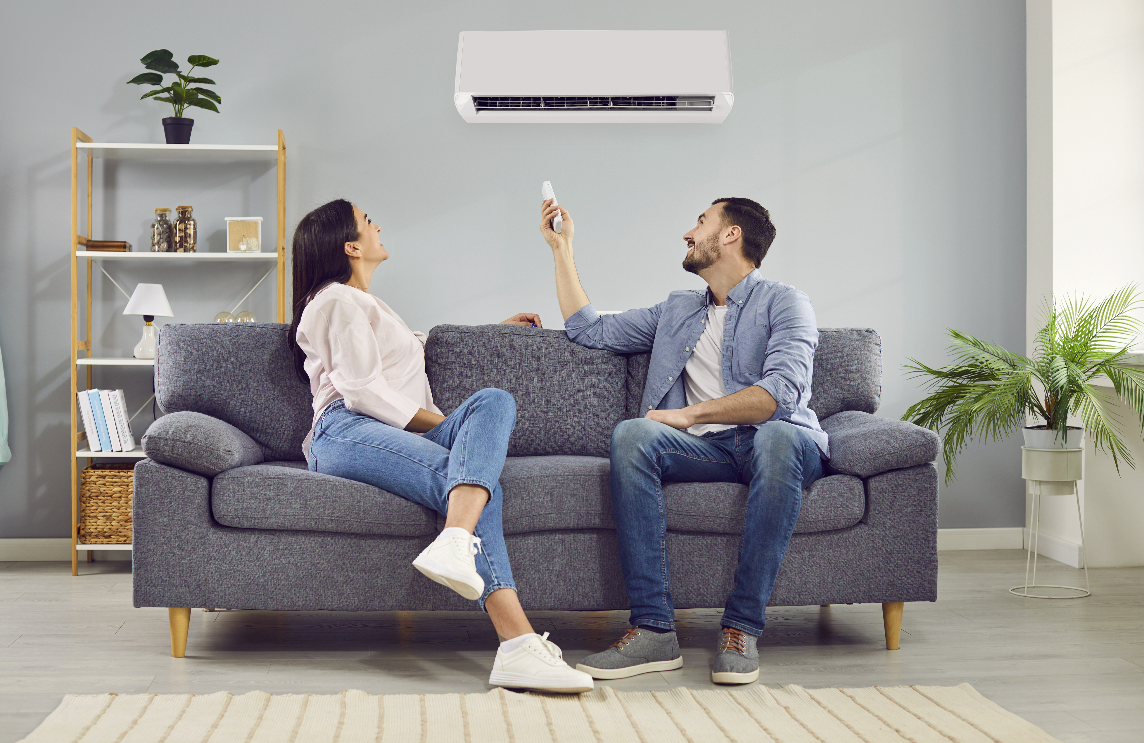 Couple on sofa enjoying ac with remote
